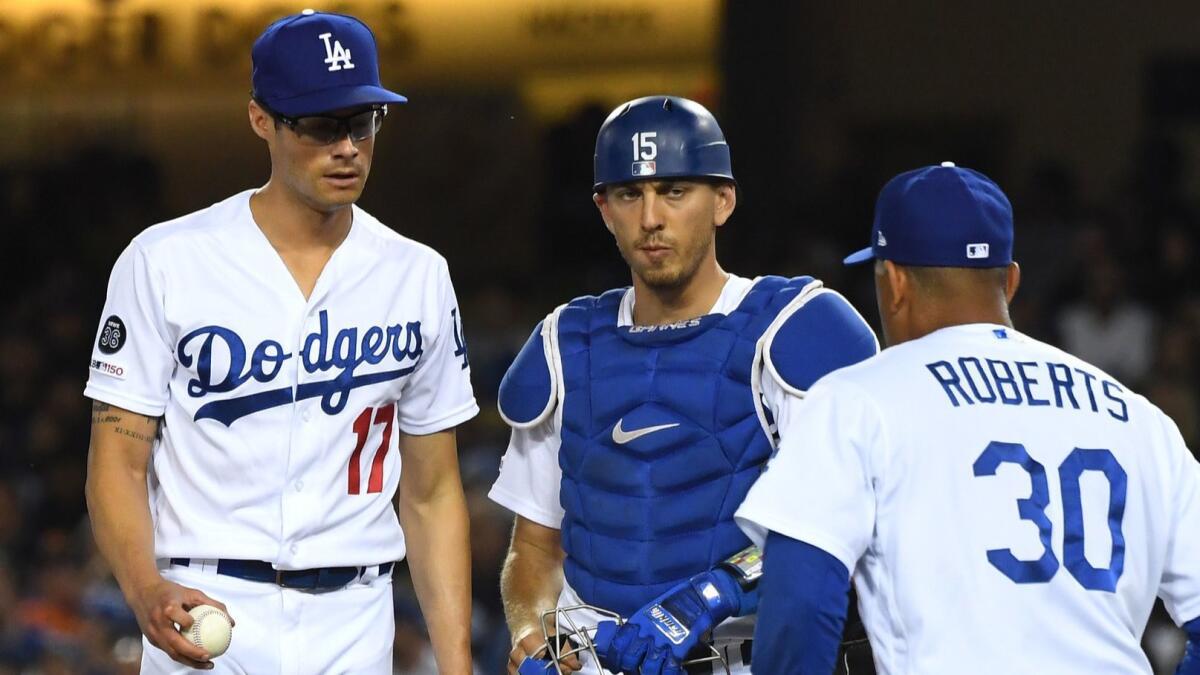 Catcher Austin Barnes looks on as manager Dave Roberts pulls Joe Kelly in the seventh inning against the San Francisco Giants at Dodger Stadium.