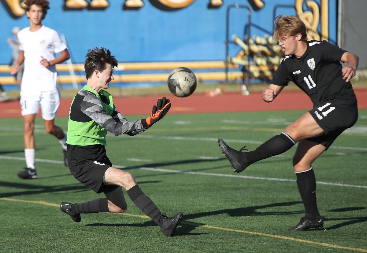 Laguna Beach goalkeeper Cole Anderson, left, deflects a shot wide of the goal.