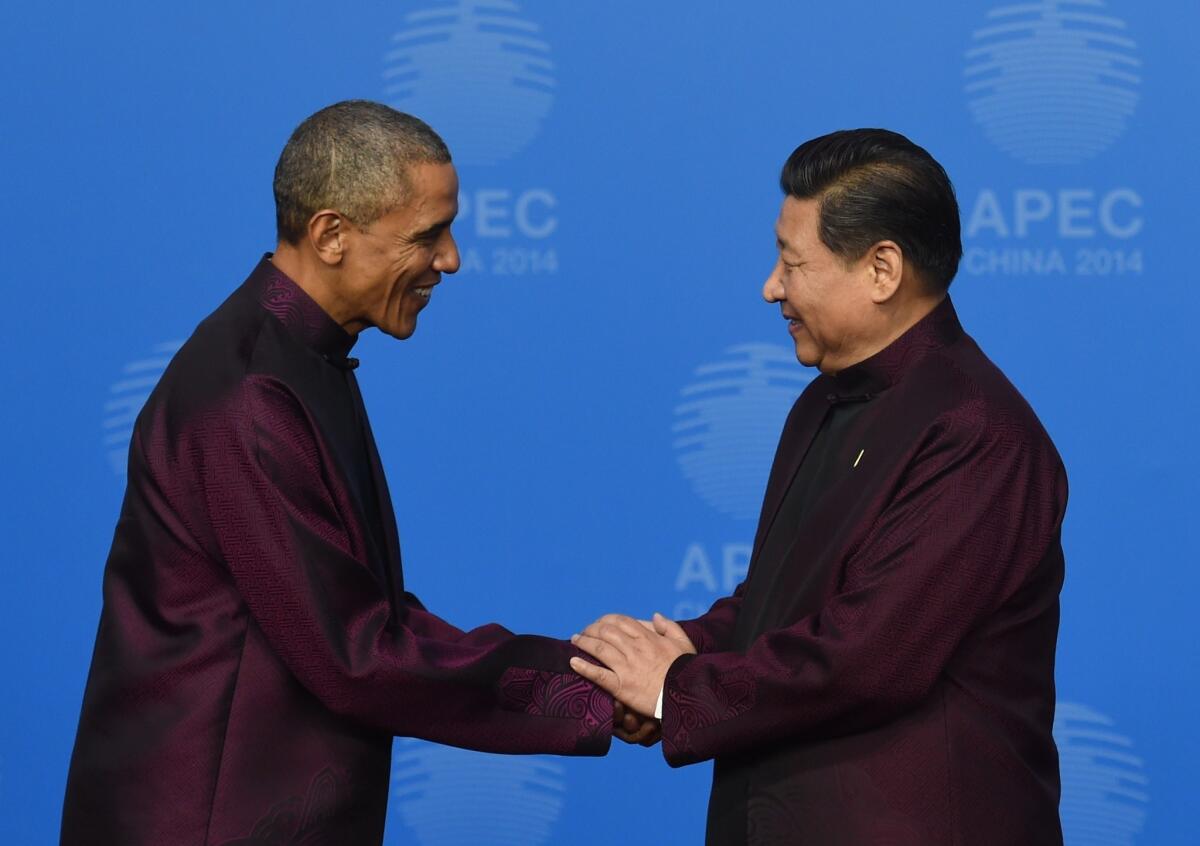 President Barack Obama is welcomed Monday by Chinese President Xi Jinping as he arrives for Asia-Pacific Economic Cooperation Summit banquet in Beijing.