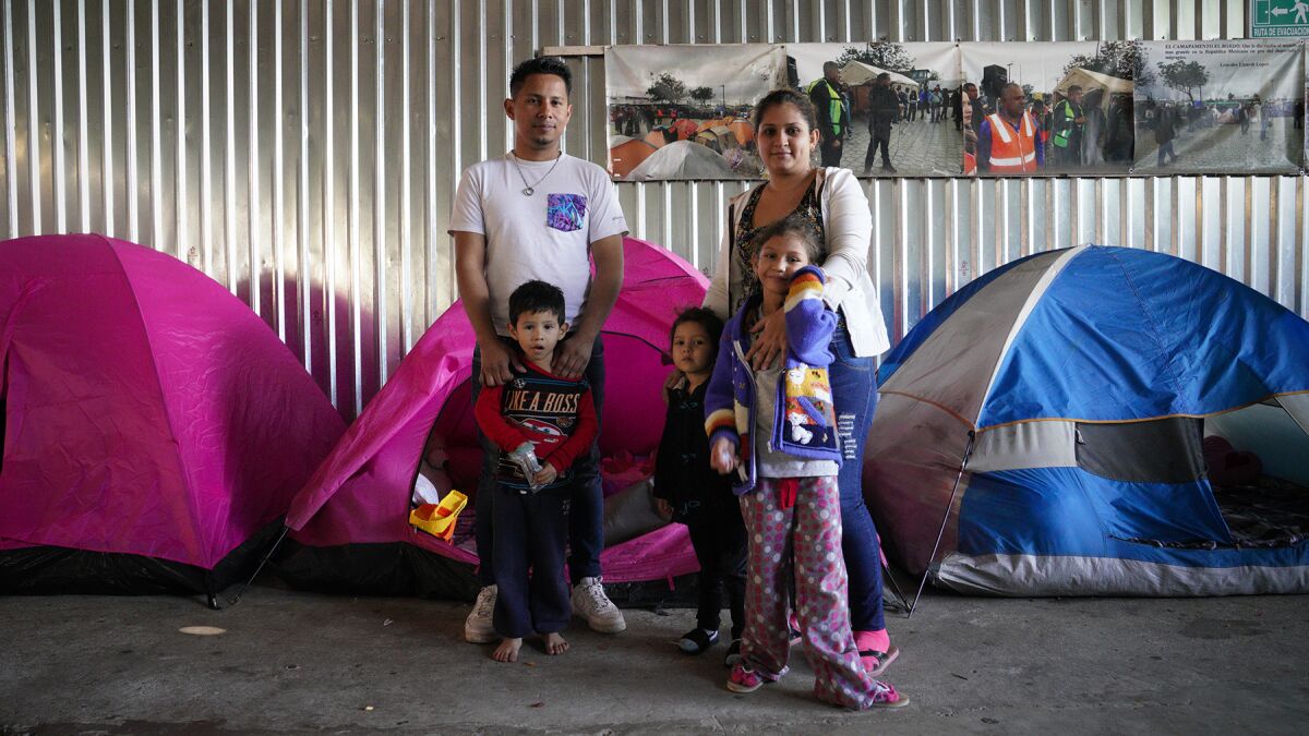 David Enamorado, 32, from Honduras shares a small tent with his family at the Movimiento Juventud shelter in Tijuana. Enamorado is waiting for his asylum request to be processed in the U.S. With Enamorado is his wife, Wendy, 24, and their children.