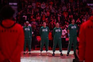 Boston forward Matt Ryan, second from left, stands for the national anthem before an NBA last March.