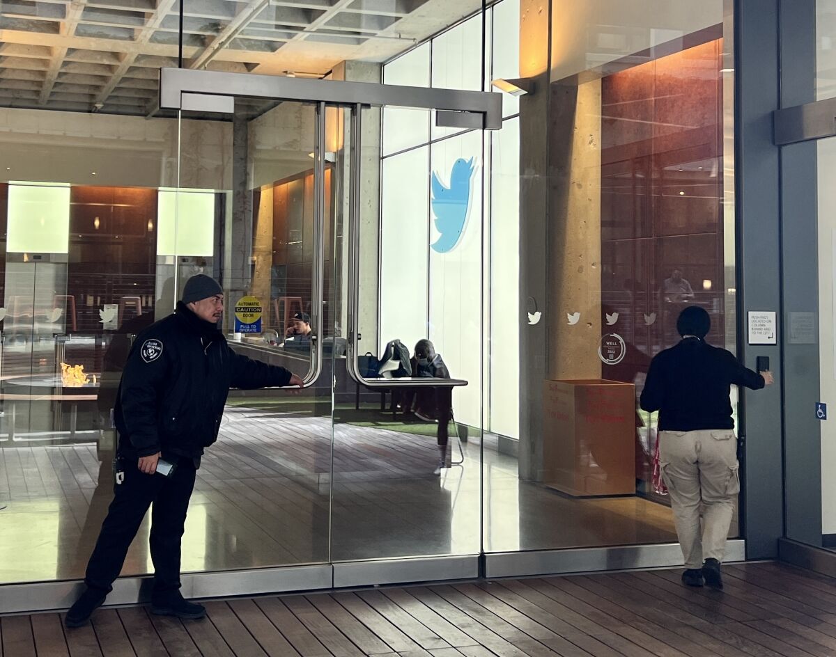 Two people outside glass doors at Twitter's headquarters