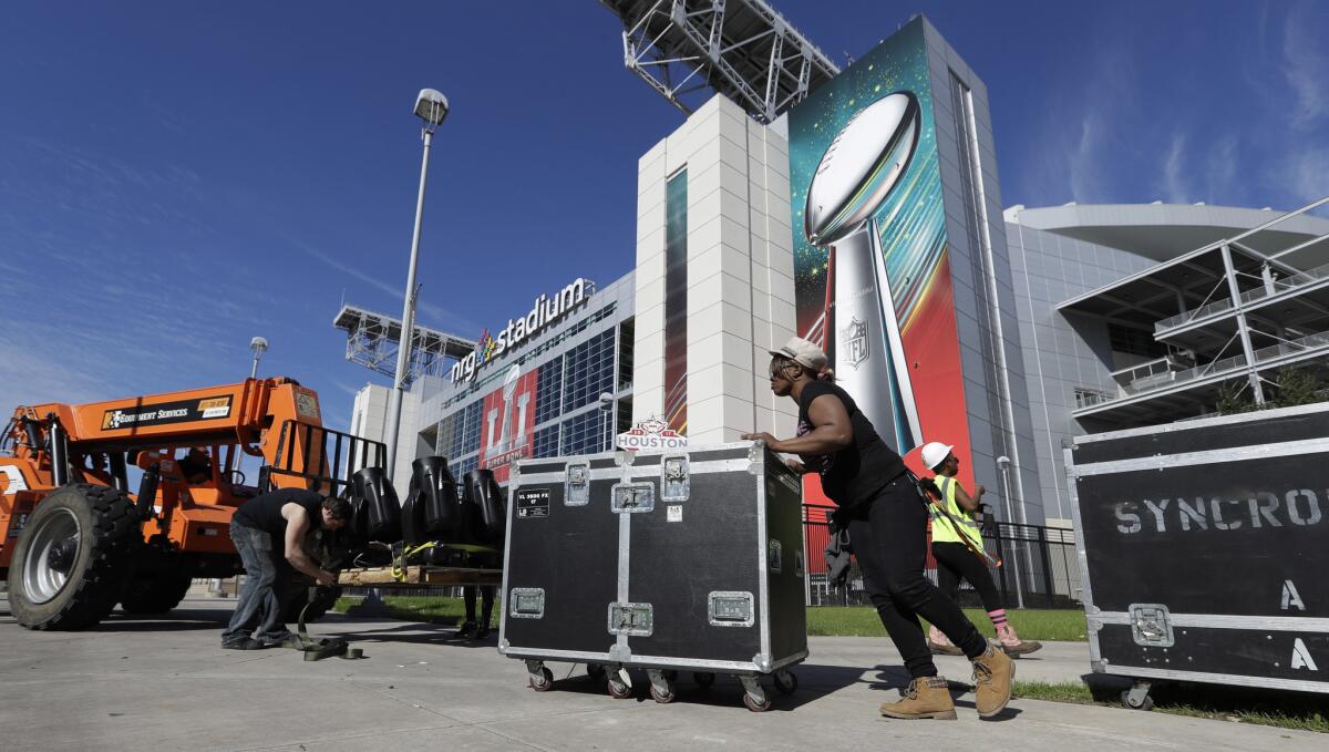 Varios trabajadores preparan y mueven equipo durante la puesta a punto del estadio NRG de Houston donde se celebrará la final de la NFL el 5 de febrero.
