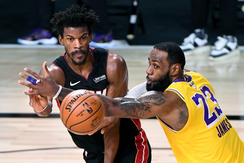 ORLANDO, FLORIDA OCTOBER 6, 2020-Lakers LeBron James tries to break up a pass from Heat's Jimmy Butler.