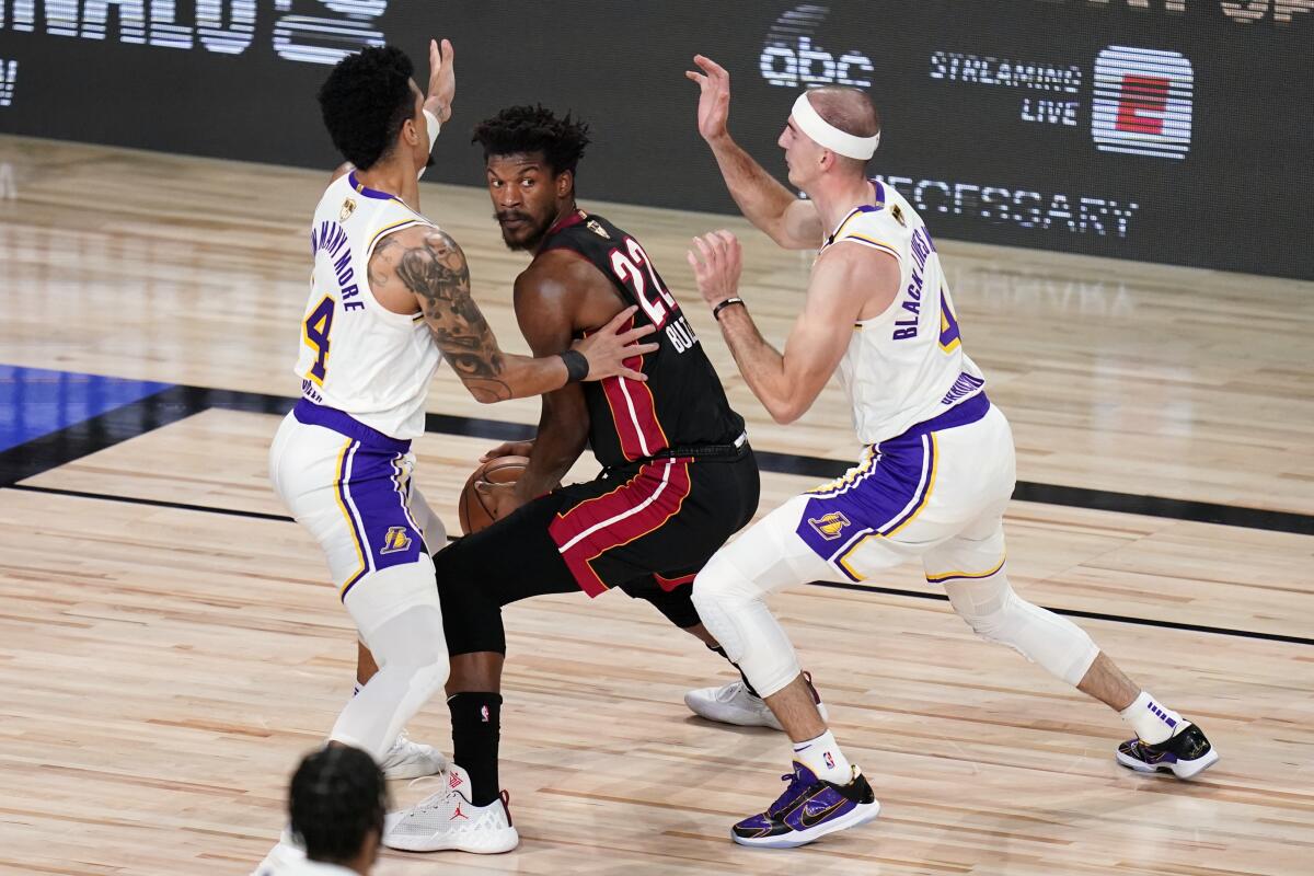 Lakers guards Kentavious Caldwell-Pope and Alex Caruso trap Heat forward Jimmy Butler during Game 6.