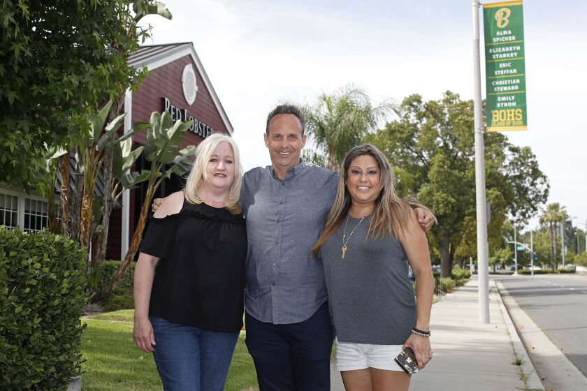 Parents, left to right, Michelle Groudas, Jason Clements and Stephanie Wiemann, after raising $4,500, worked with the city to hang banners of the Brea Olinda High School graduates all over Brea.