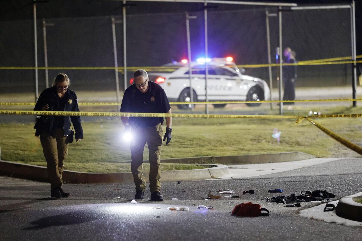 Tulsa Police officers investigate the area outside of the McLain High School football stadium after a shooting during a football game Friday, Sept. 30, 2022 in Tulsa, Okla. Police say a teenager was killed and another was wounded in a shooting at a high school homecoming football game in Oklahoma Friday night. (Mike Simons/Tulsa World via AP)