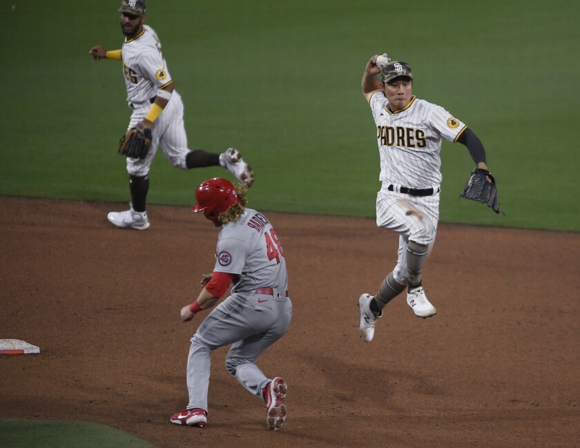 San Diego Padres shortstop Ha-Seong Kim (7) throws next to St. Louis Cardinals' Harrison Bader (48) as he turns a double play on Tommy Edman during the sixth inning of a baseball game Friday, May 14, 2021, in San Diego. (AP Photo/Denis Poroy)