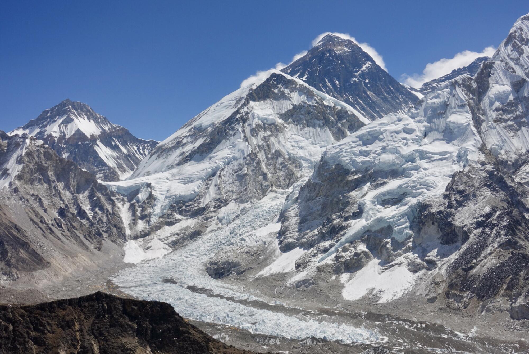 Snow and ice on the approach to Mt. Everest, with clouds forming off its peaks