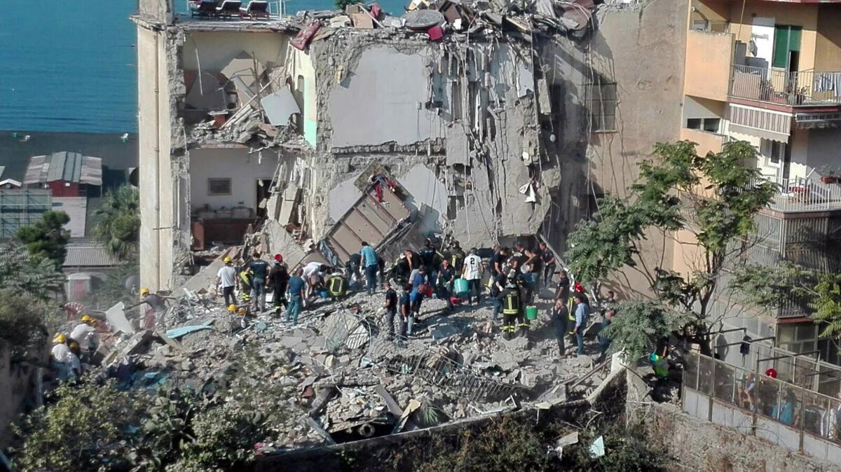 Rescuers work amid the rubble of a building that collapsed in Torre Annunziata, Italy, on July 7.