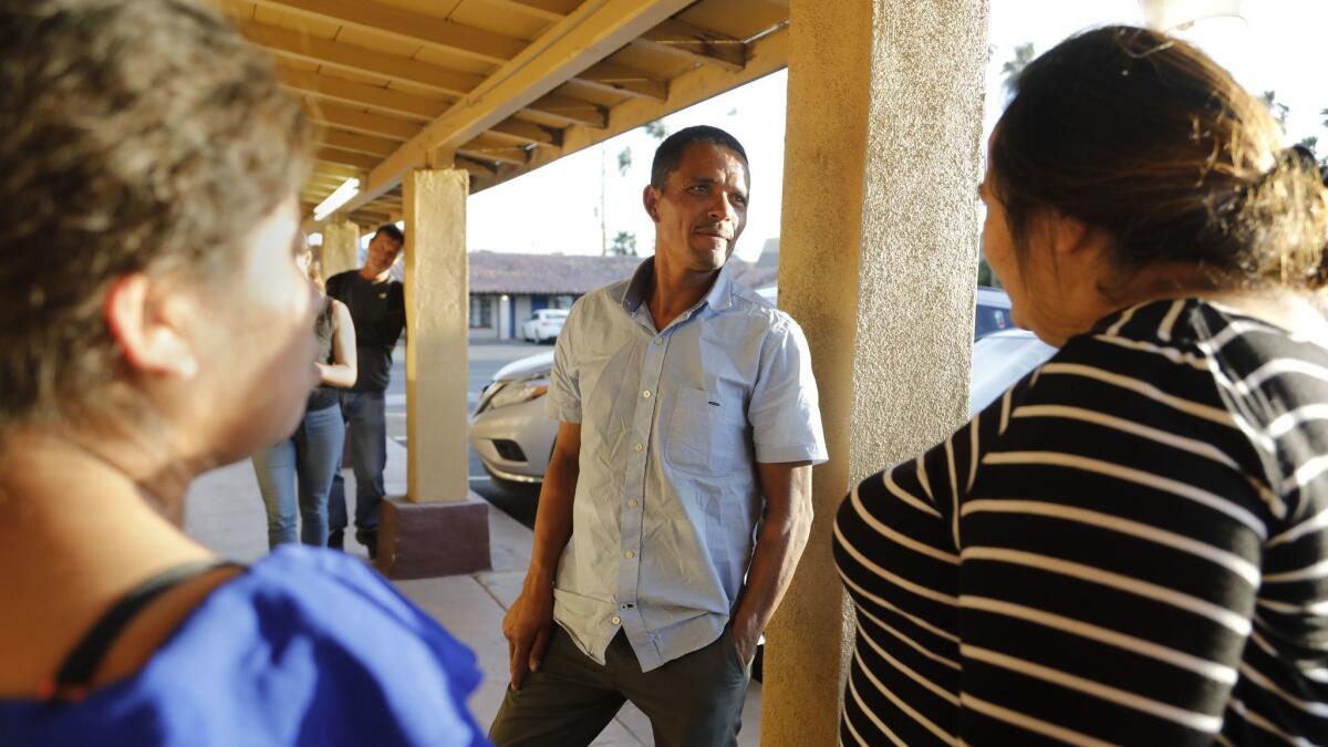 Redin, center, from Honduras, joins two other Central American parents at a Calexico motel after they were released from a detention facility.