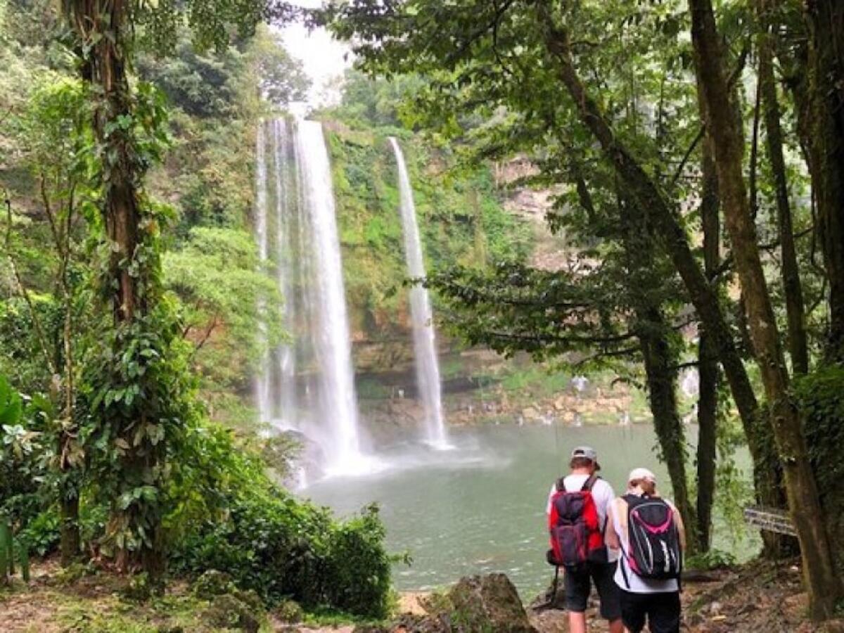 Dos turistas frente a la catarata de Misol Ha en la selva del estado de Chiapas, México.