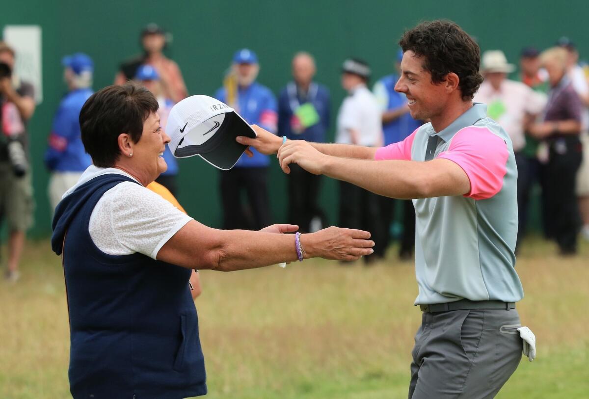 Rory McIlroy greets his mother, Rose, on the 18th green after clinching his victory in the 143rd Open Championship on Sunday. McIlroy's mother was not present for his victories at the 2011 U.S. Open or 2012 PGA Championship, so he dedicated the victory to her during his speech at the awards ceremony.