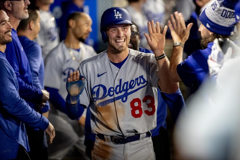 Dodgers third baseman Michael Busch (83) gets high-fives after scoring against the Angels on June 20, 2023 in Anaheim.