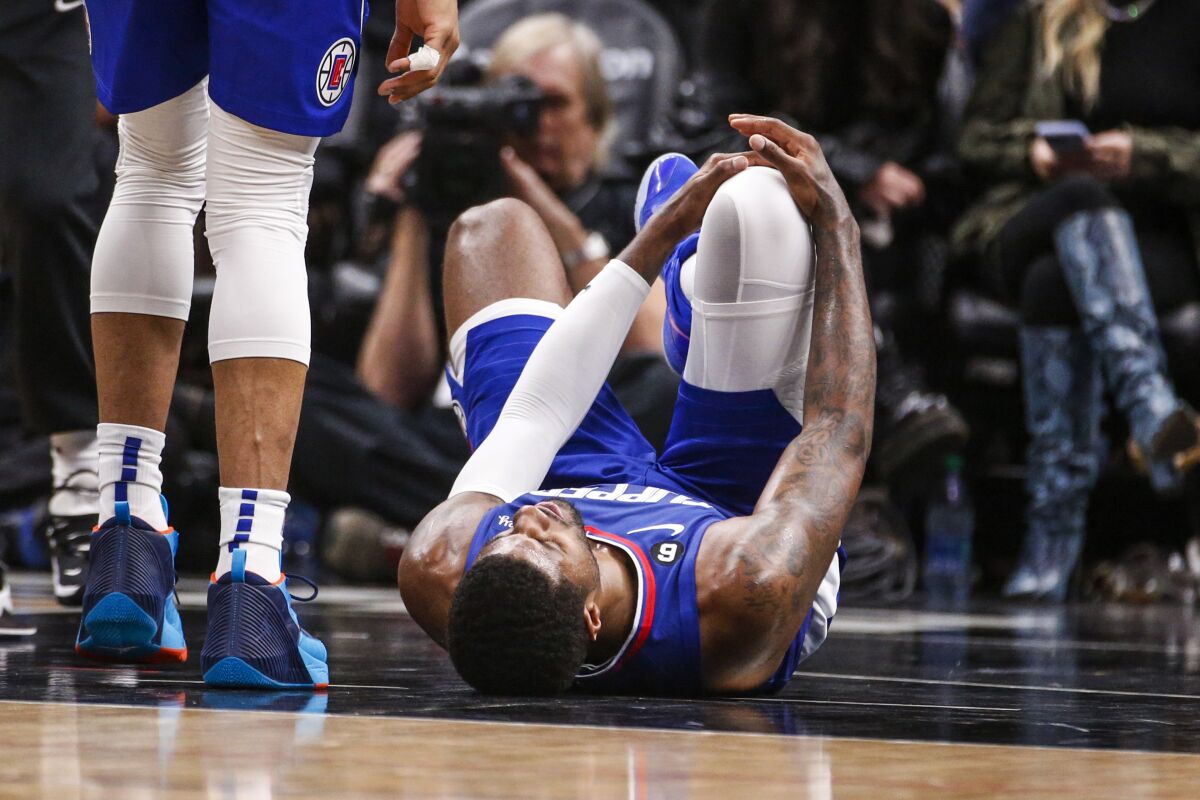 Paul George, alero de los Clippers de Los Ángeles, está tendido en la duela después de sufrir una lesión 