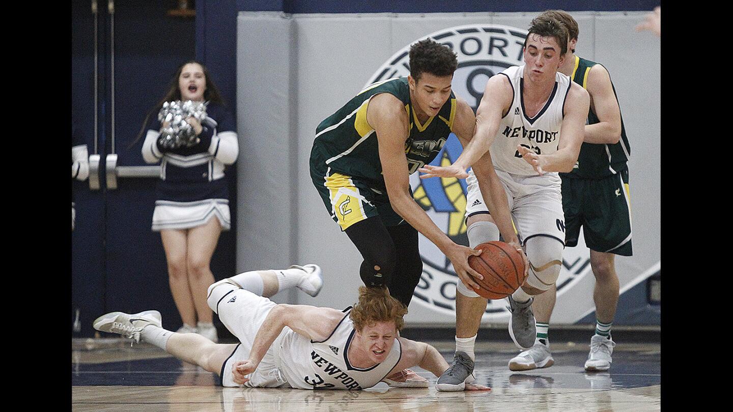 Newport Harbor's Zack Swies, left, and Jake Bashore scrable for a loose ball with Edison's Josh Phillips during a Sunset League game on Monday, January 29.