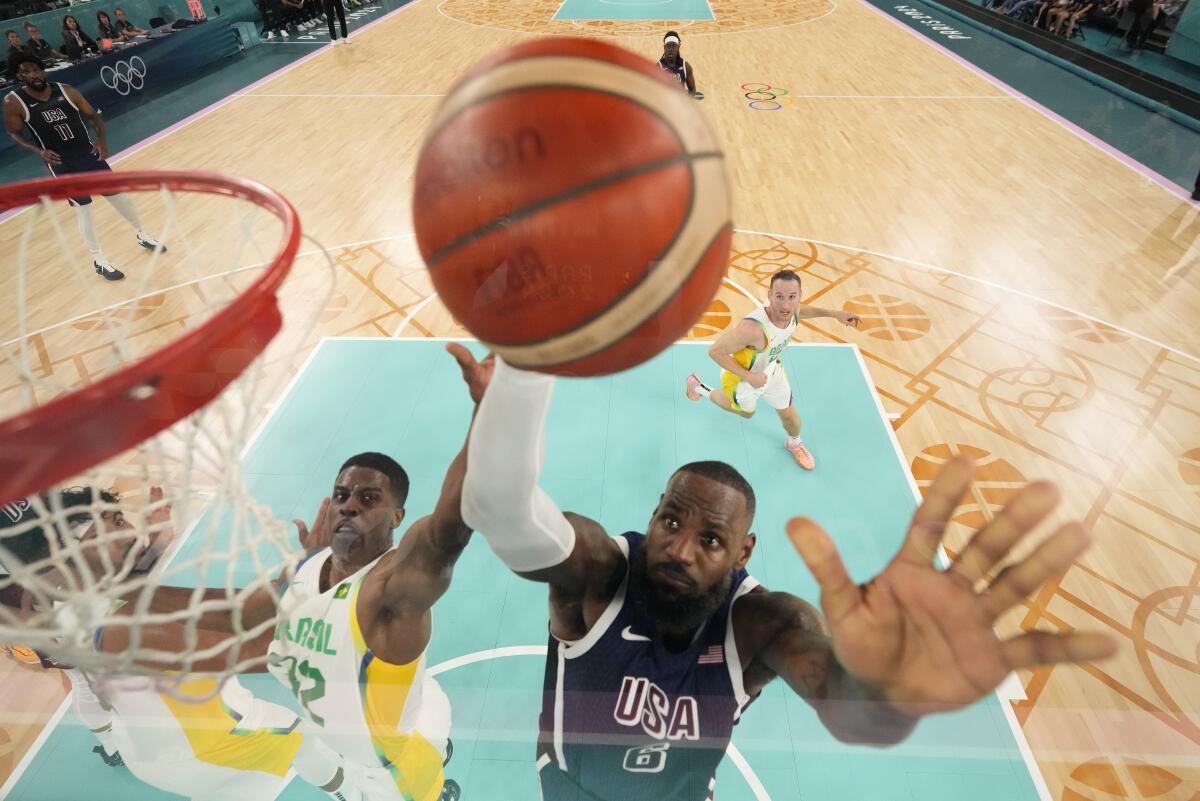 LeBron James, right, is challenged by Brazil's Georginho de Paula during their quarterfinal game on Tuesday in Paris.