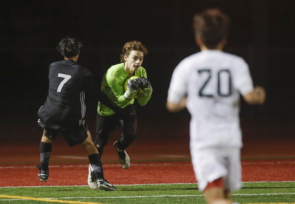 Estancia's Esa Asmraz (7) takes a shot on Costa Mesa goalie Ethan Smithlin, who makes the stop on Wednesday.