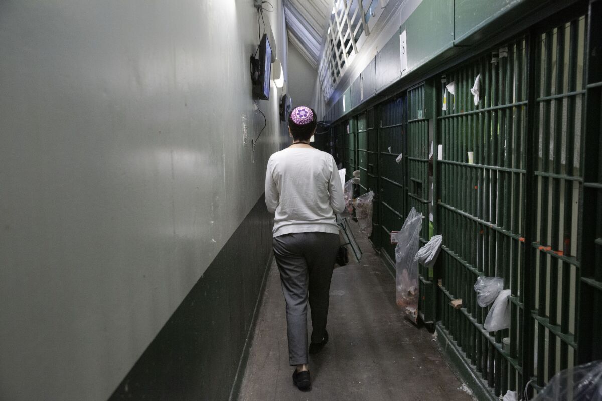 Inmates call out to Erlick as she walks through a row of cells. (Liz Moughon / Los Angeles Times)