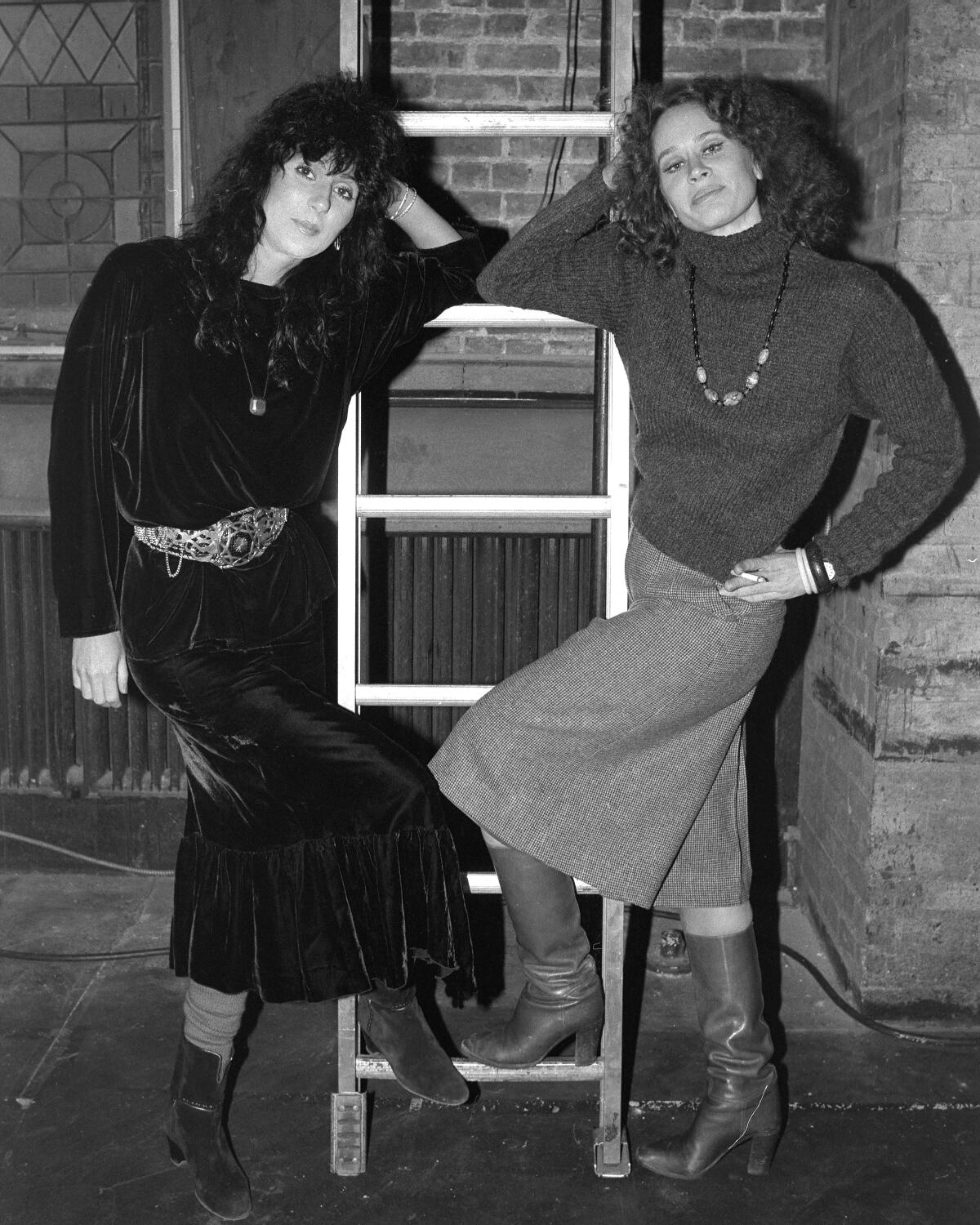 Two actors pose backstage at a theater.