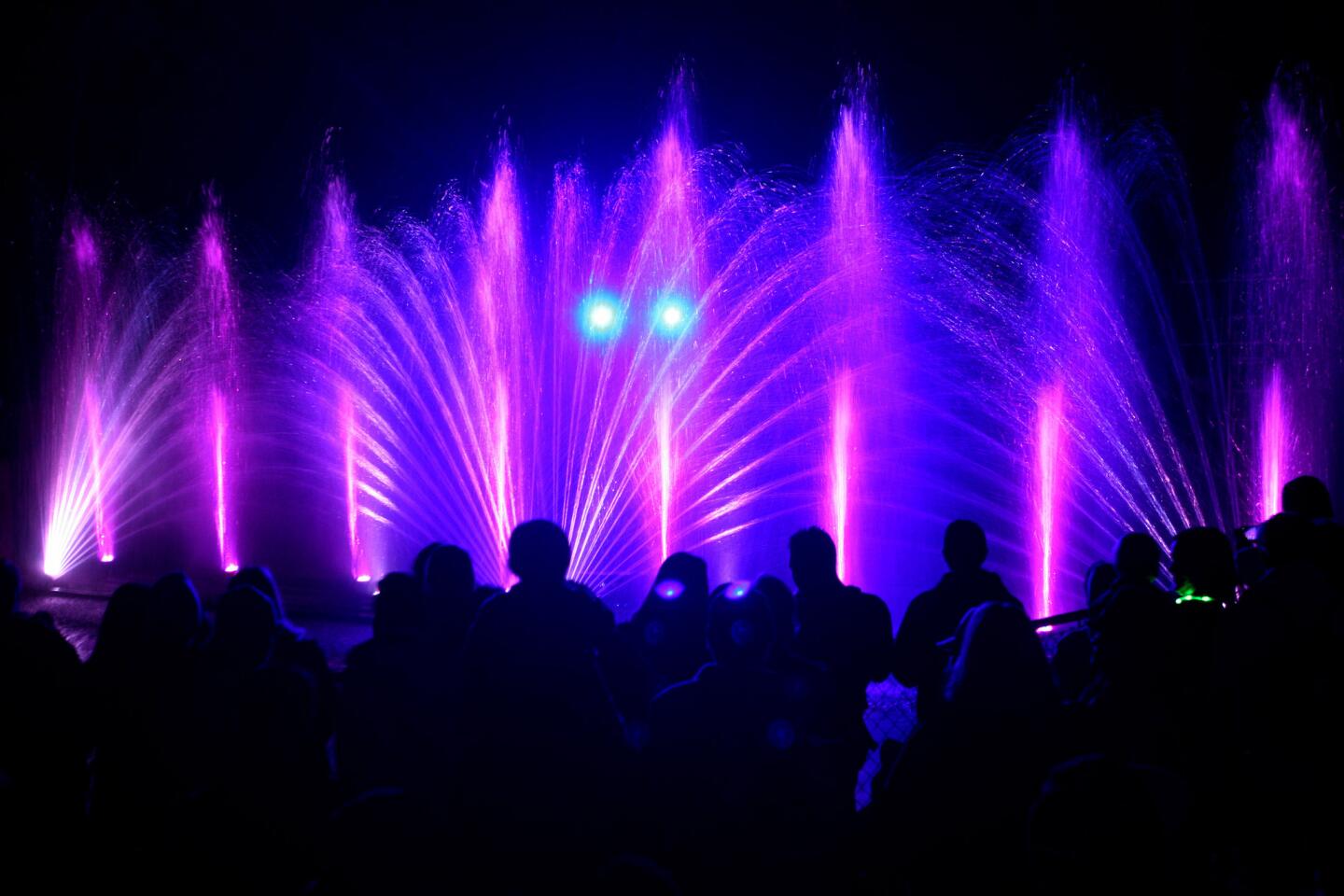 A large crowd enjoys a water and light show during the L.A. Zoo Lights event, in Los Angeles on Monday, December 21, 2015. Light displays can be seen at 15 locations including the entry plaza, the reindeer romp village, meerkat madness, electric elephants, and a twinkle tunnel. There are lighted monkeys hanging out on palm trees and a light show at LightScapes where scenes are projected on a curtain of water. The event runs nightly through January 3rd.