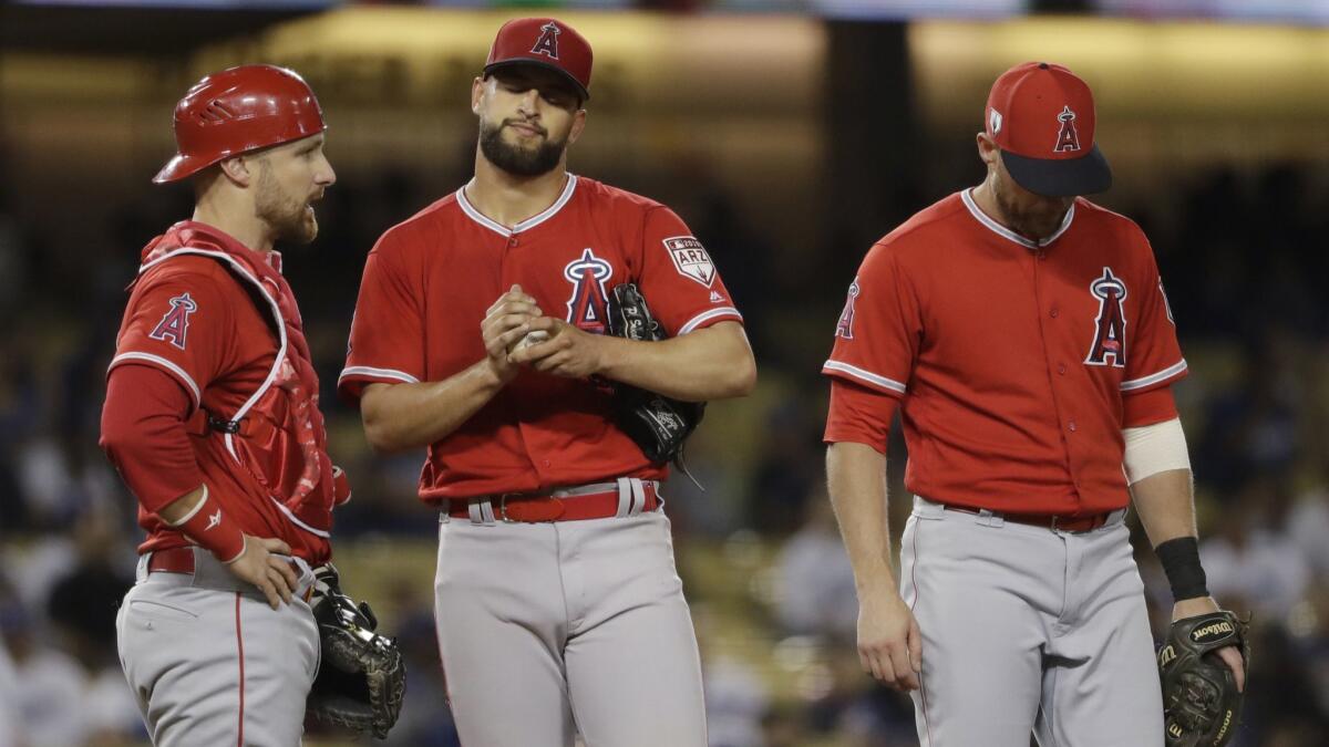Angels starter Patrick Sandoval, center, after giving up an RBI single to the Dodgers' Justin Turner during the second inning of a preseason game Tuesday.