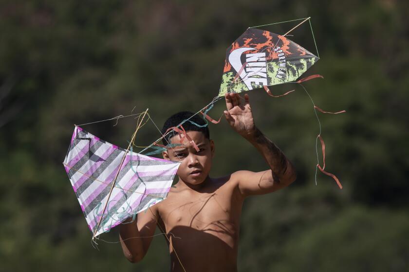 Un joven sostiene cometas durante un festival en la favela de Turano, en Río de Janeiro, el domingo 7 de julio de 2024. (AP Foto/Bruna Prado)