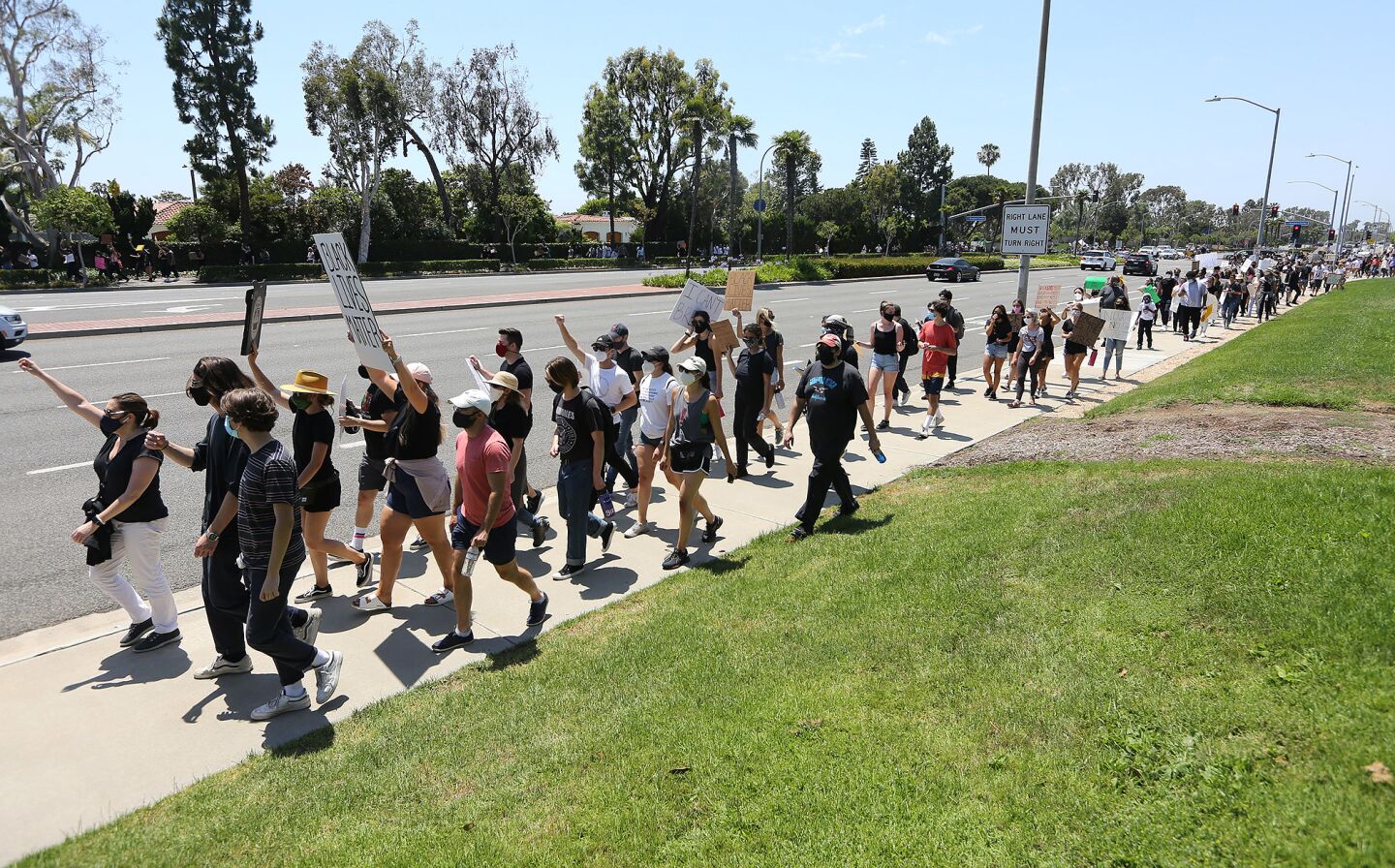 Protesters march from the Fashion Island entrance during a Black Lives Matter protest which began at MacArthur Boulevard and East Coast Highway in Newport Beach on Wednesday.