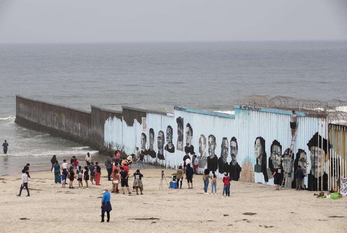  People view a new border mural.