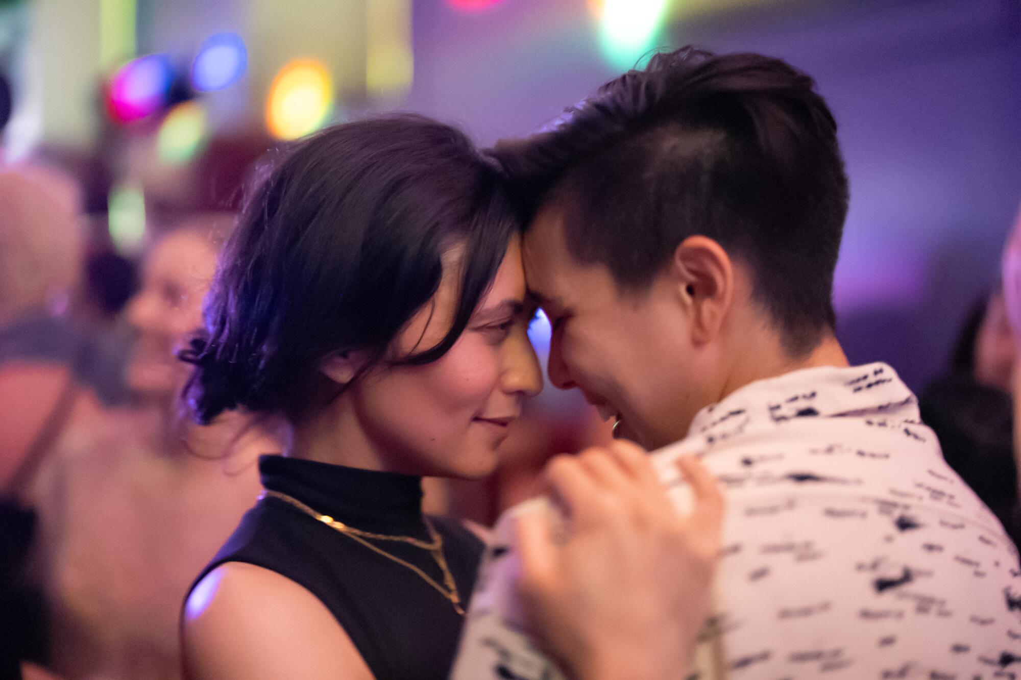 Two women dance cheek to cheek during Queer Prom night at a bar in San Francisco