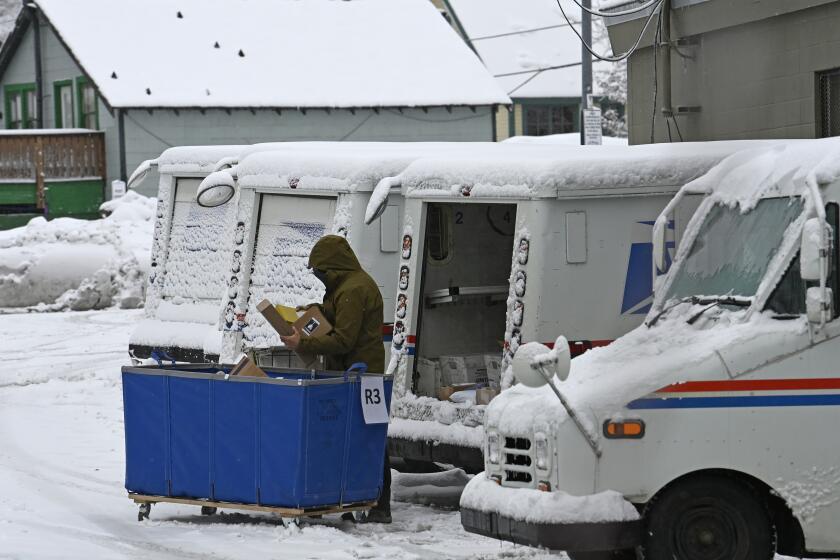 FILE - A mail carrier loads a mail truck with mail, March 1, 2024, in Lake Tahoe, Calif. The USPS announced on Tuesday, April 23, that it will follow through with its plan to reroute Reno-area mail processing to Sacramento, a move that drew bipartisan ire from Nevada lawmakers while raising questions about the rate at which mail ballots can be processed in a populous part of a crucial swing state. (AP Photo/Andy Barron, File)