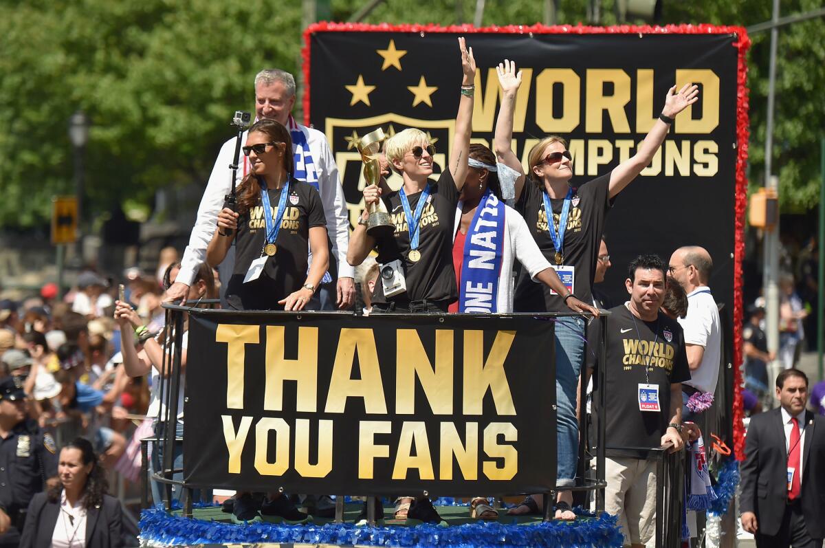 U.S. soccer players Carli Lloyd and Megan Rapinoe wave to fans during the New York City ticker-tape parade for the Women's World Cup champions on Friday.