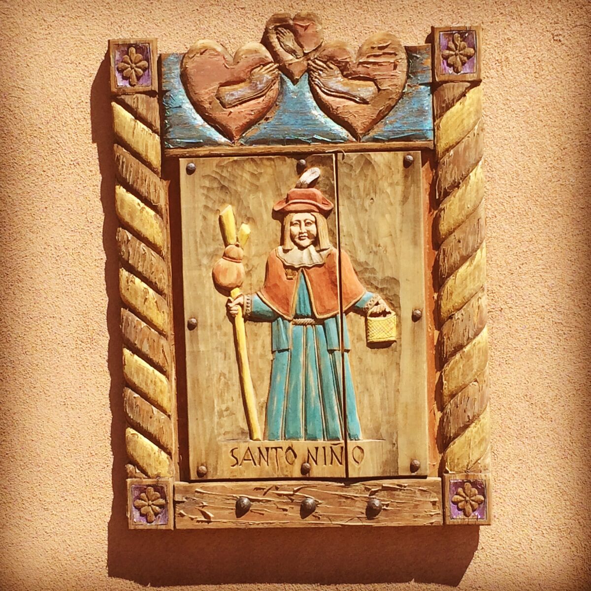A wooden plaque featuring the Santo Niño de Atocha at the Santuario de Chimayó in New Mexico.