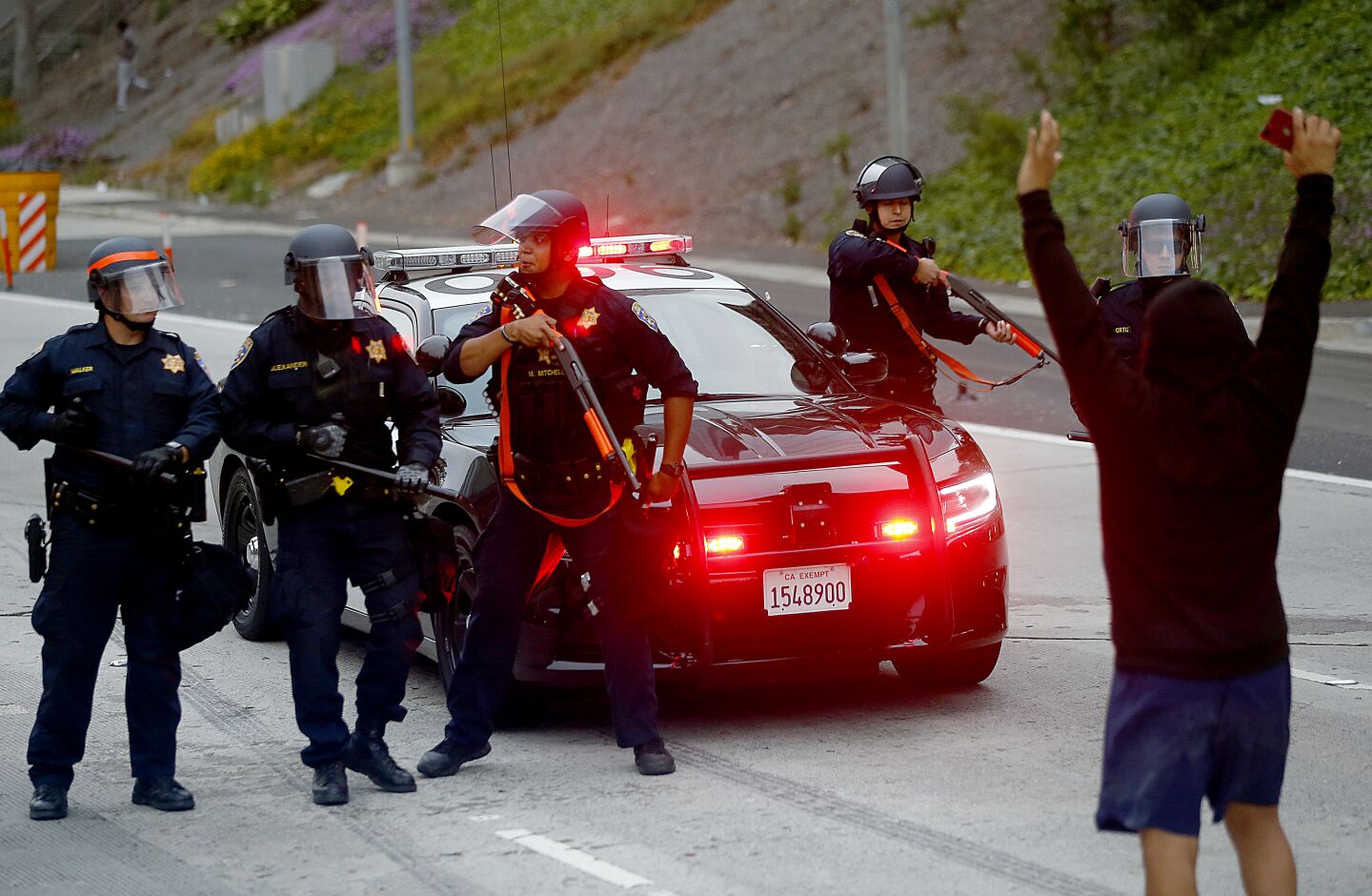 Police officers assume a defensive stance as a protester approaches them on the 110.