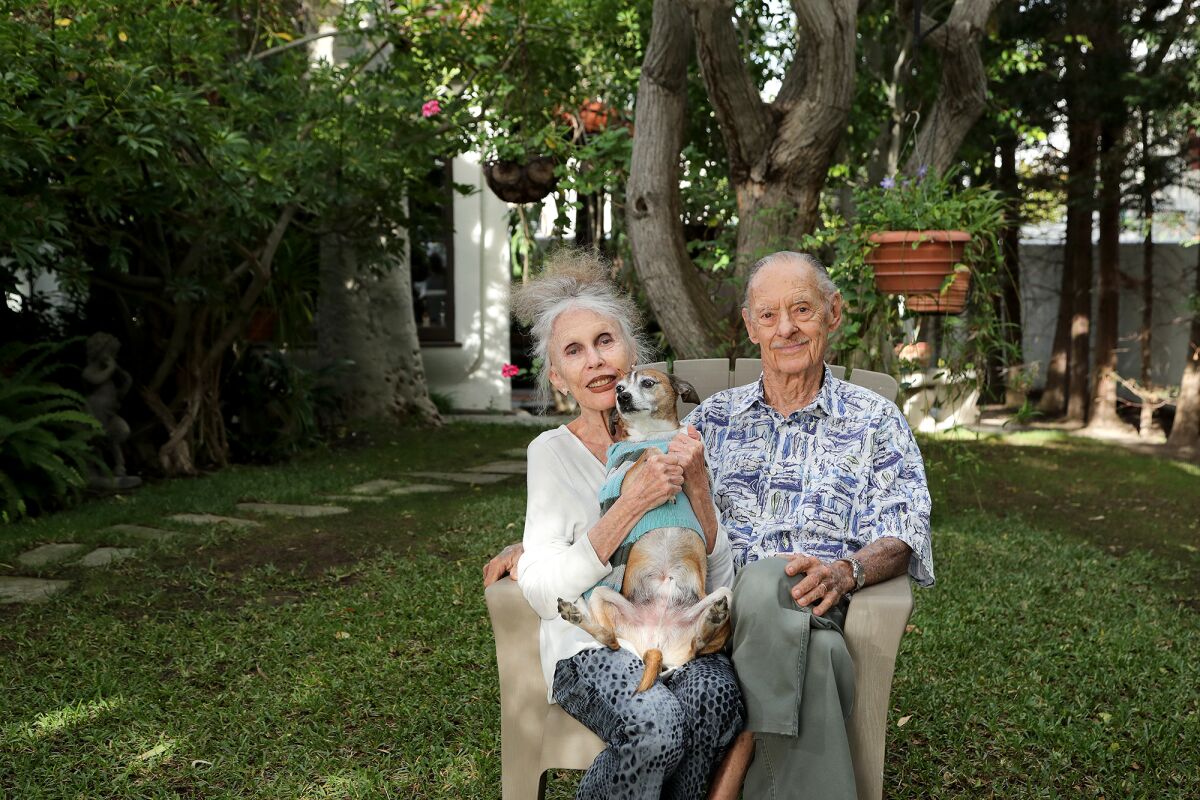 Joan and Frank Randall pose with Bucky at their home garden on Lido Isle in Newport Beach.