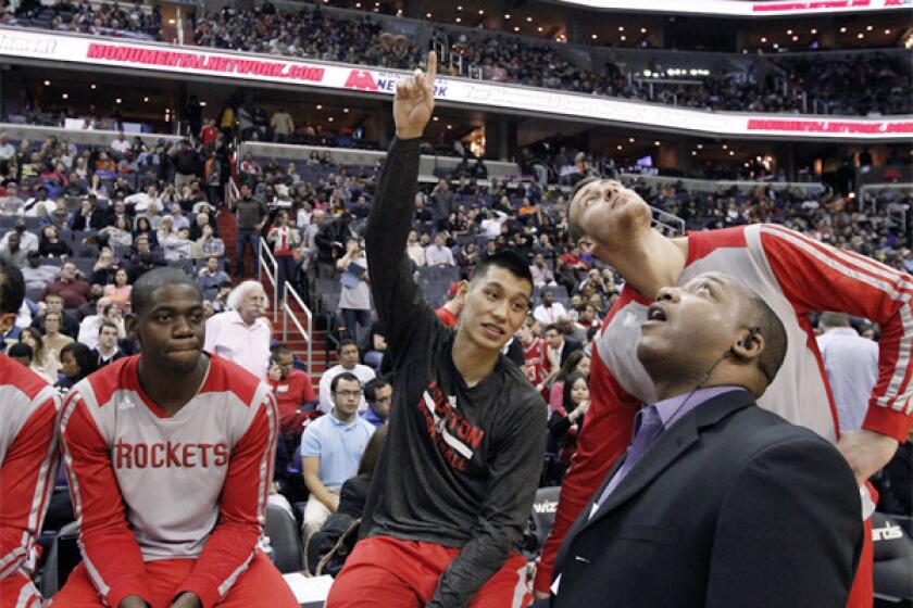 Houston forward Ronnie Brewer, left, guard Jeremy Lin and forward Donatas Motiejunas talk with Bryant Savage, director of security services for the Rockets, about the water leak in the ceiling Saturday in Washington, D.C.