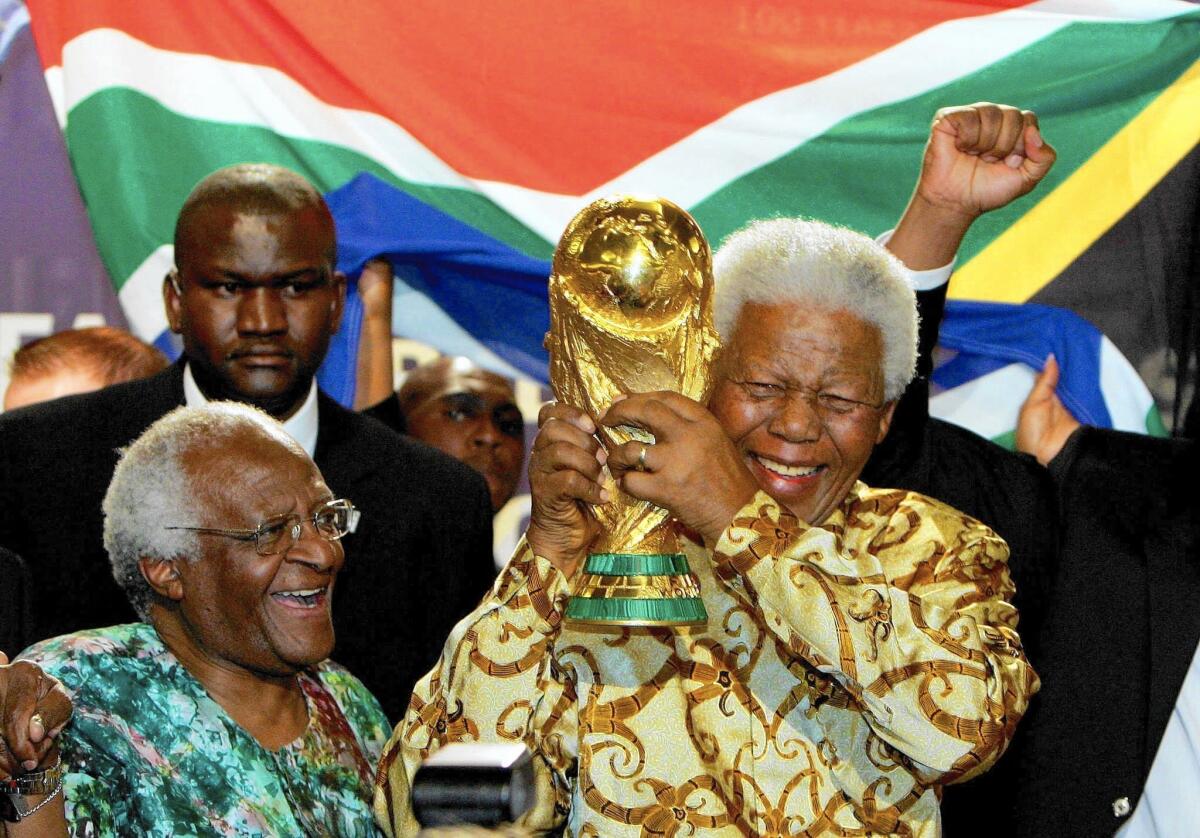 Nelson Mandela, with Capetown Archbishop Desmond Tutu, raises the Jules Rimet World Cup in Zurich in 2004, after FIFA announced that South Africa would host the 2010 World Cup.