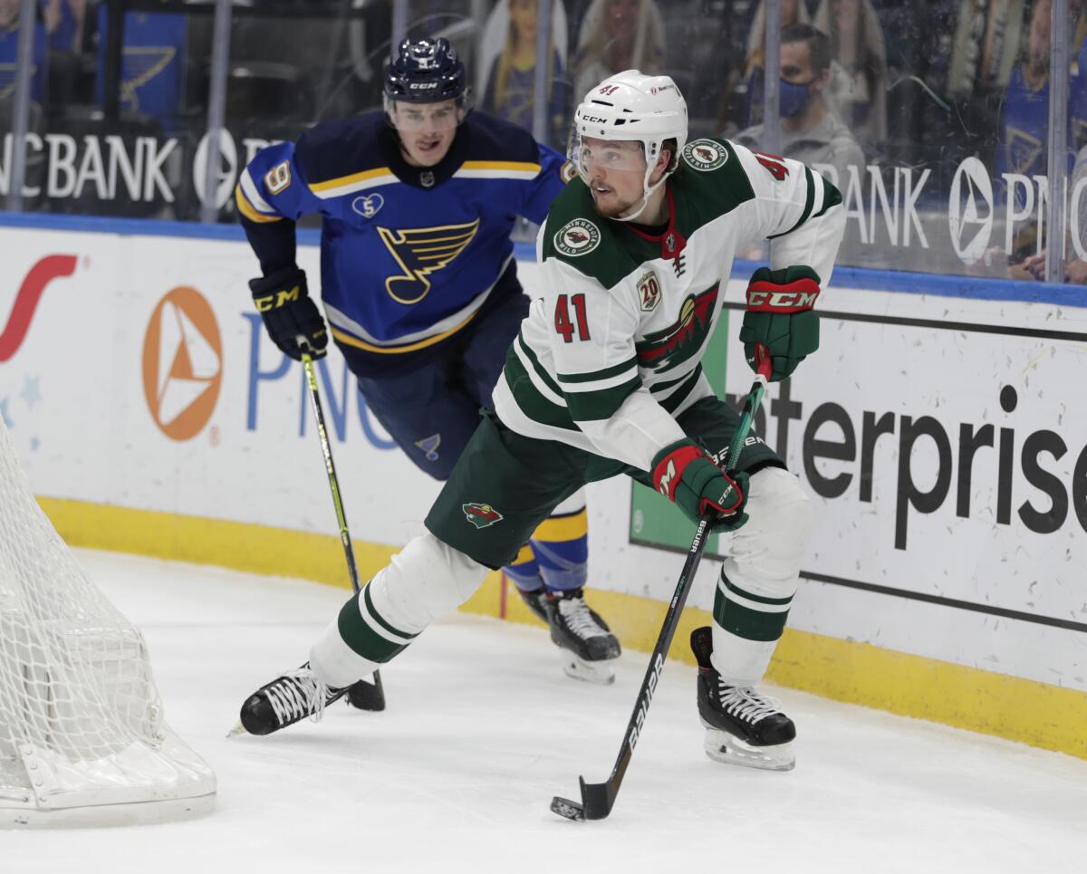 Minnesota Wild's Luke Johnson (41) controls the puck as he is pursued by St. Louis Blues' Sammy Blais (9) during the second period of an NHL hockey game Thursday, May 13, 2021, in St. Louis. (AP Photo/Tom Gannam)