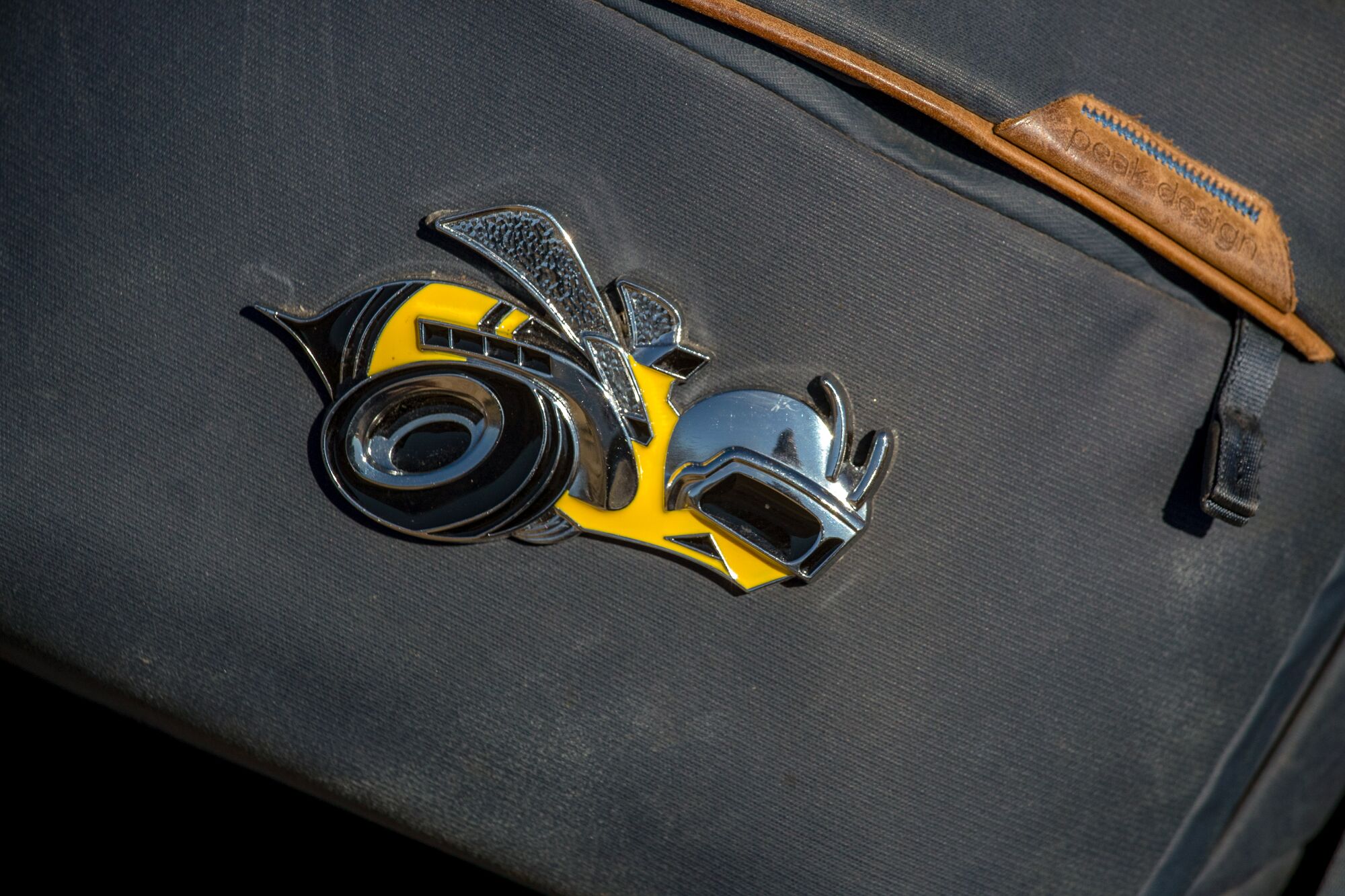 A closeup of a decal on a camera bag depicting a bee-shaped motorcycle.