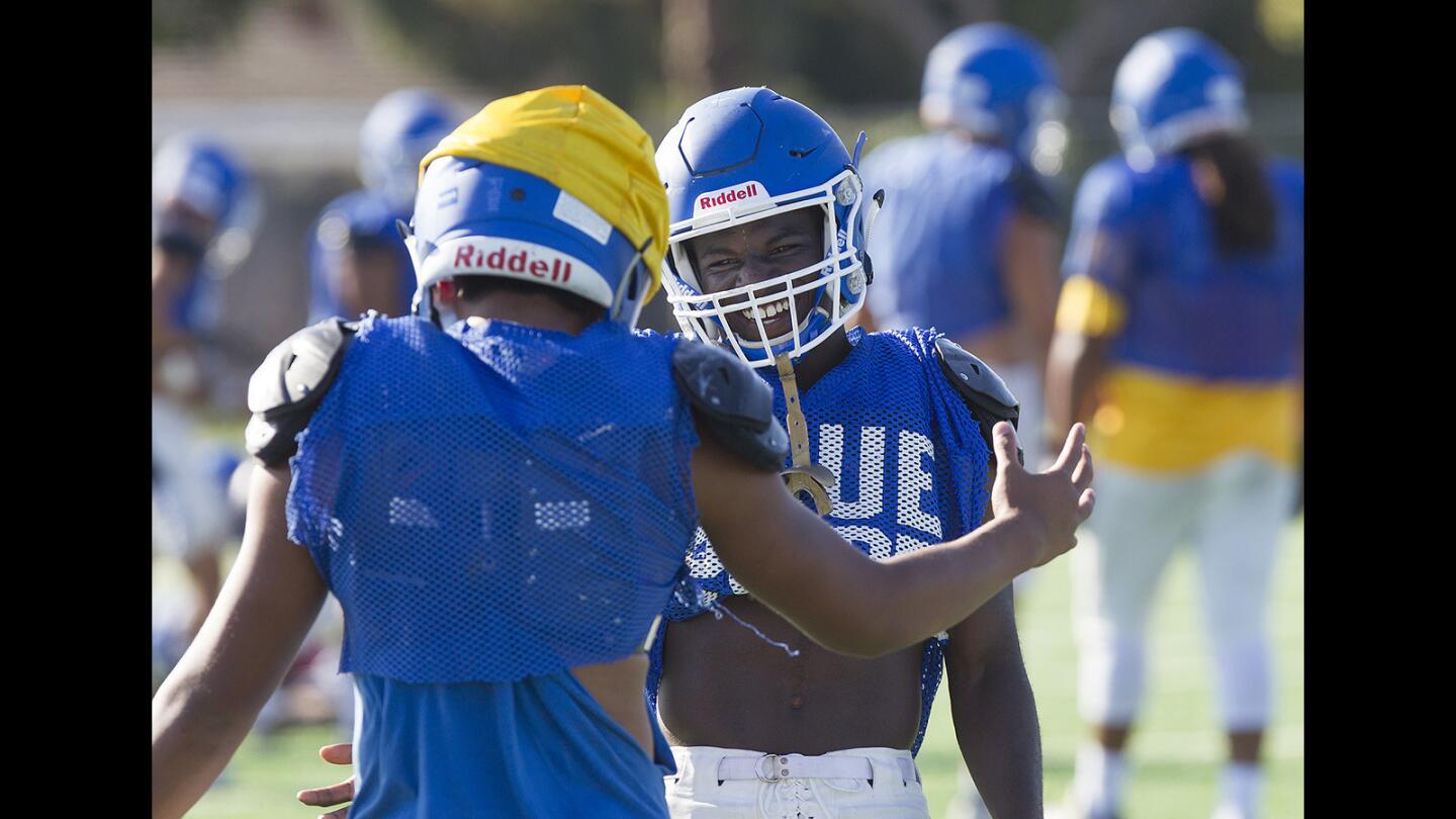 Two way player Kishaun Sykes greets a player during recent Fountain Valley football practice.