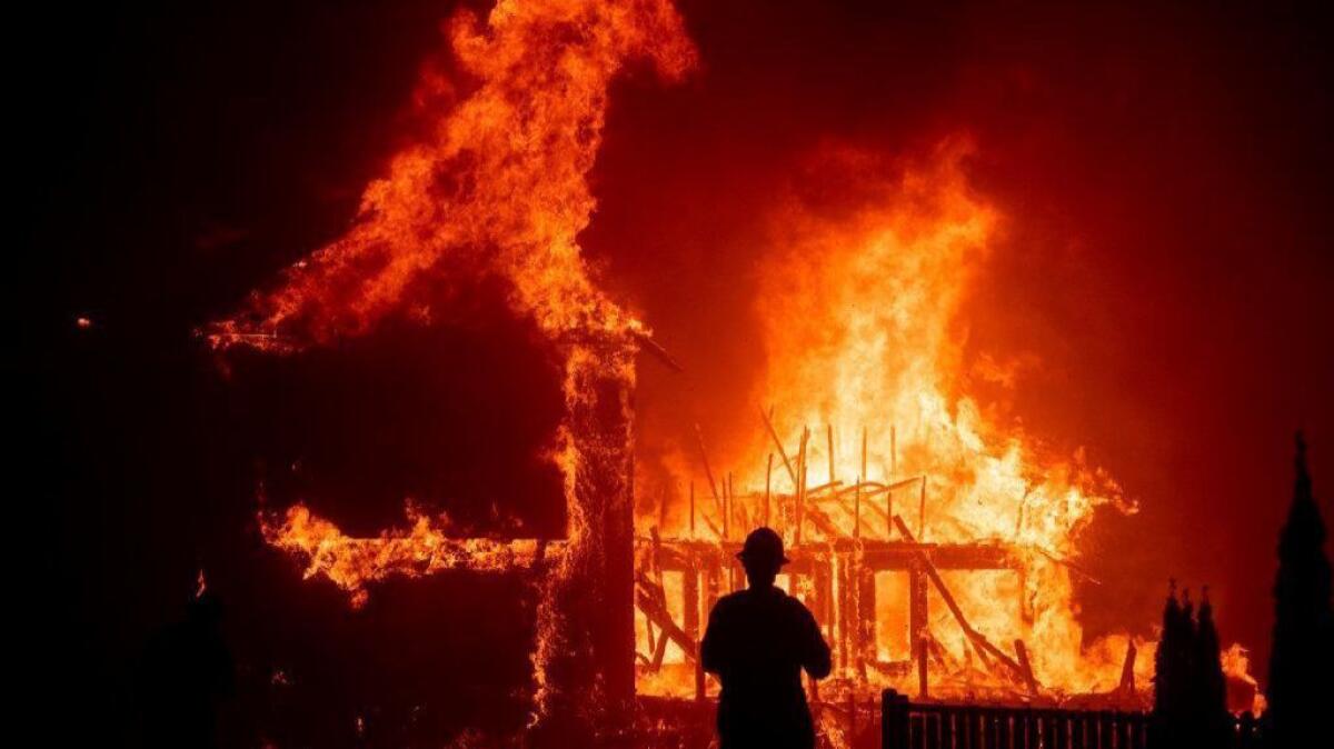 A home burns as the Camp fire rages through Paradise, Calif., on Nov. 8, 2018. Gov. Gavin Newsom wants to tap ratepayers for $10.5 billion to help utilities deal with costs they face when found responsible for igniting wildfires.
