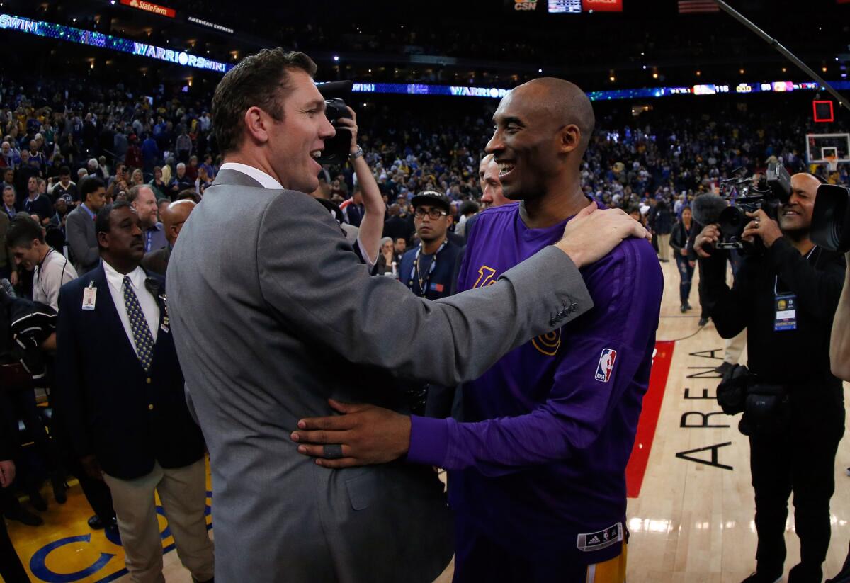 Kobe Bryant hugs Luke Walton, who was serving as the Golden State Warriors interim head coach, after a game.