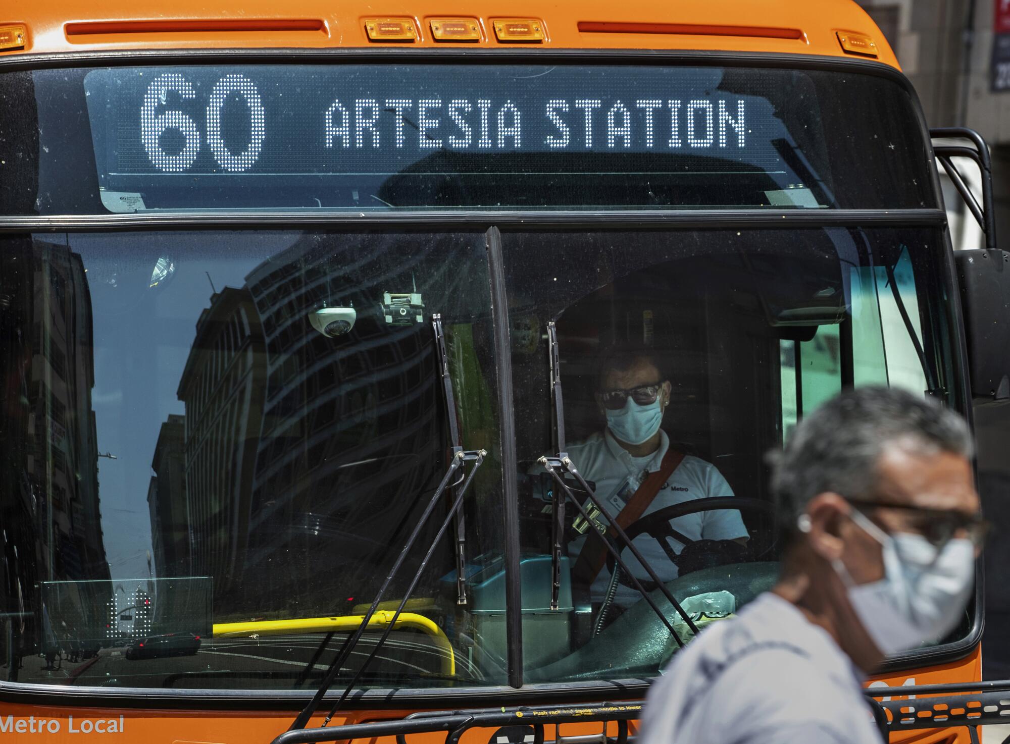 A Metro bus driver waits for passengers to board on 7th Street near Broadway in downtown Los Angeles.