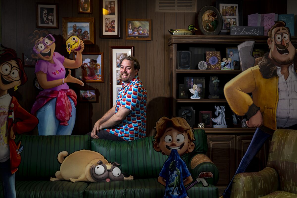 A man sits among promotional figures of his animated characters.