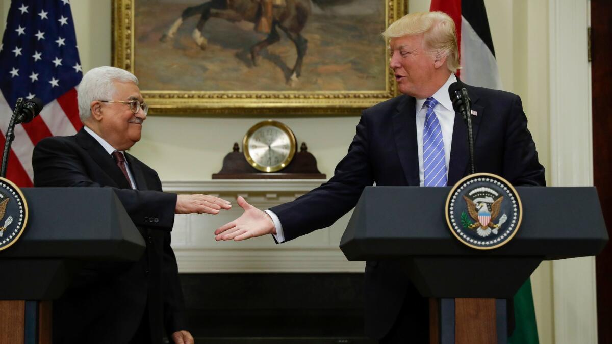 President Donald Trump reaches to shakes hands with Palestinian leader Mahmoud Abbas after speaking in the Roosevelt Room of the White House on May 3.