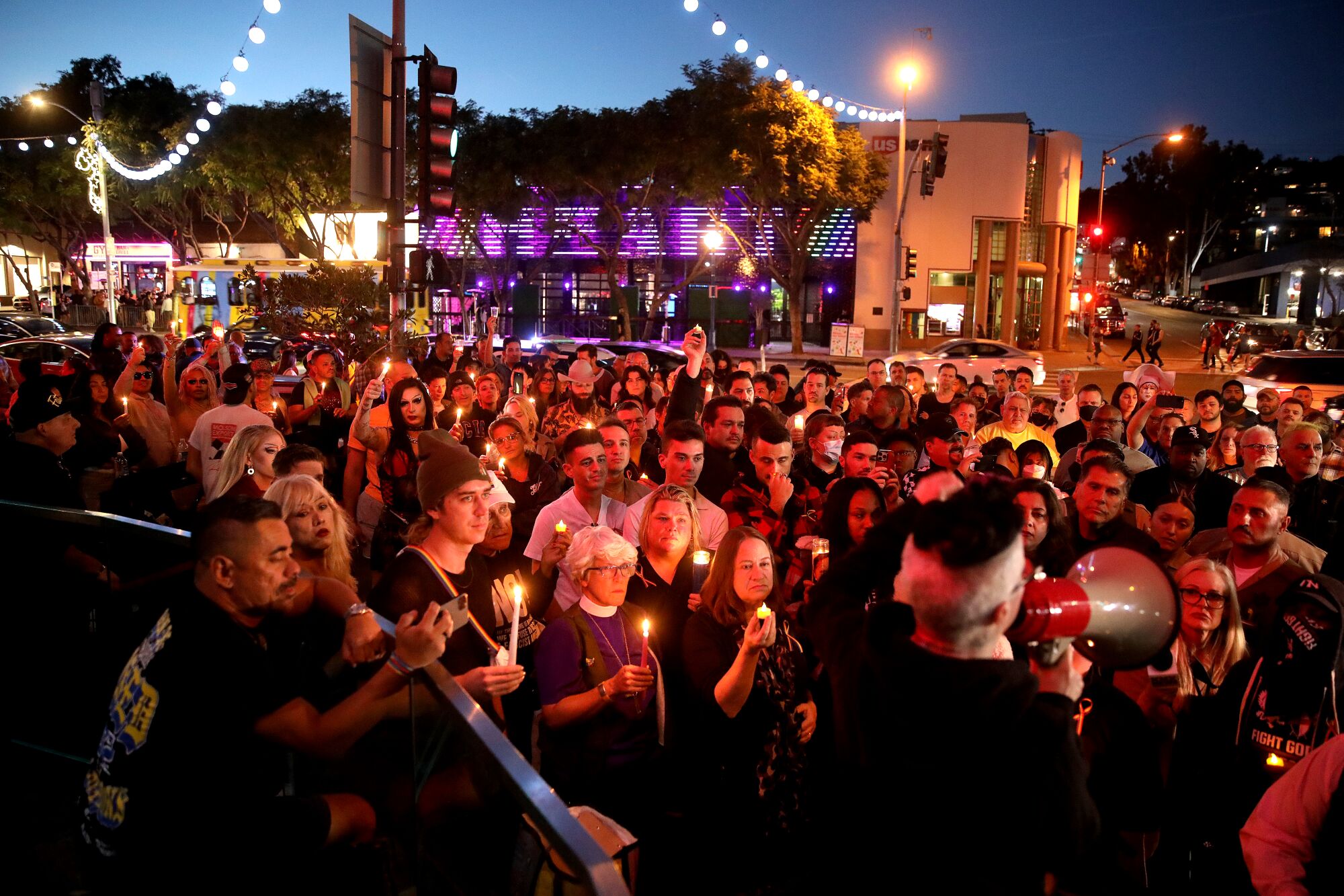 People gather to attend a candlelight vigil along Santa Monica Blvd.