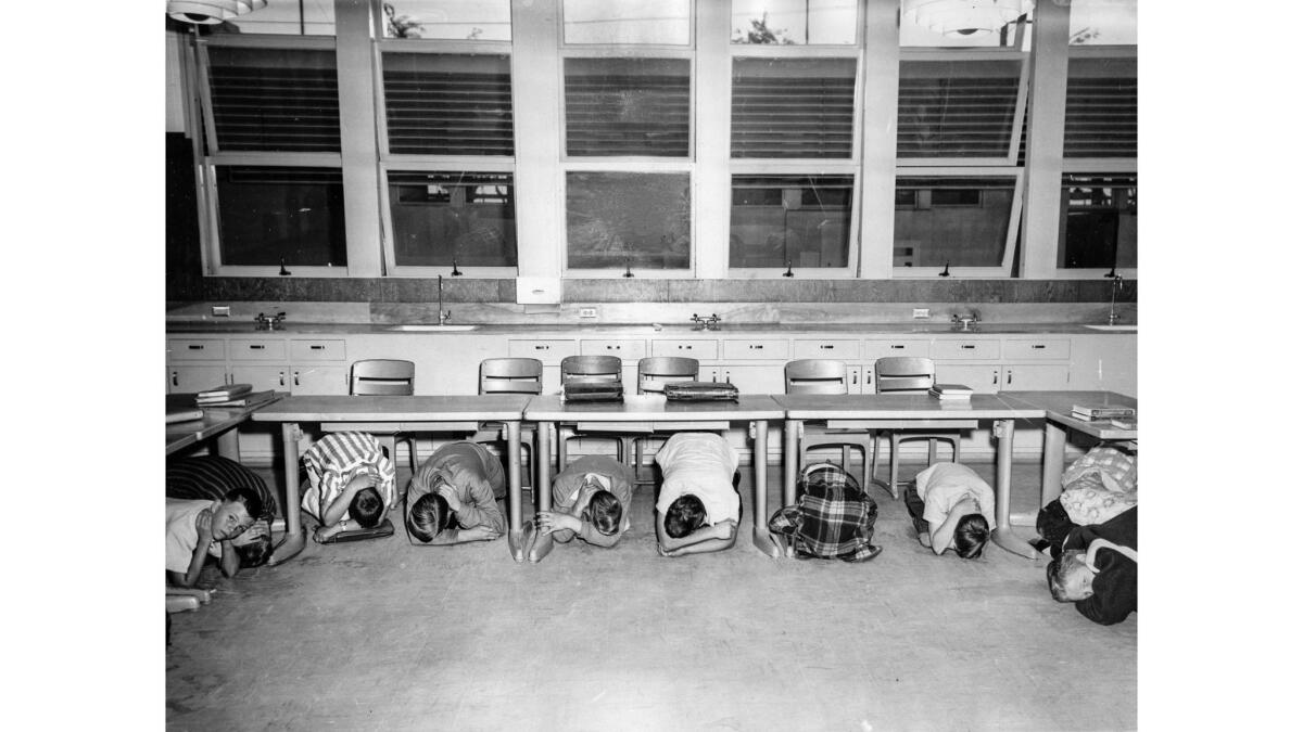May 27, 1957: Seventh graders from Sarah Robinson's class at Hosler Junior High School in Lynwood cover their faces and hide under desks during full-scale red alert civil defense drill.