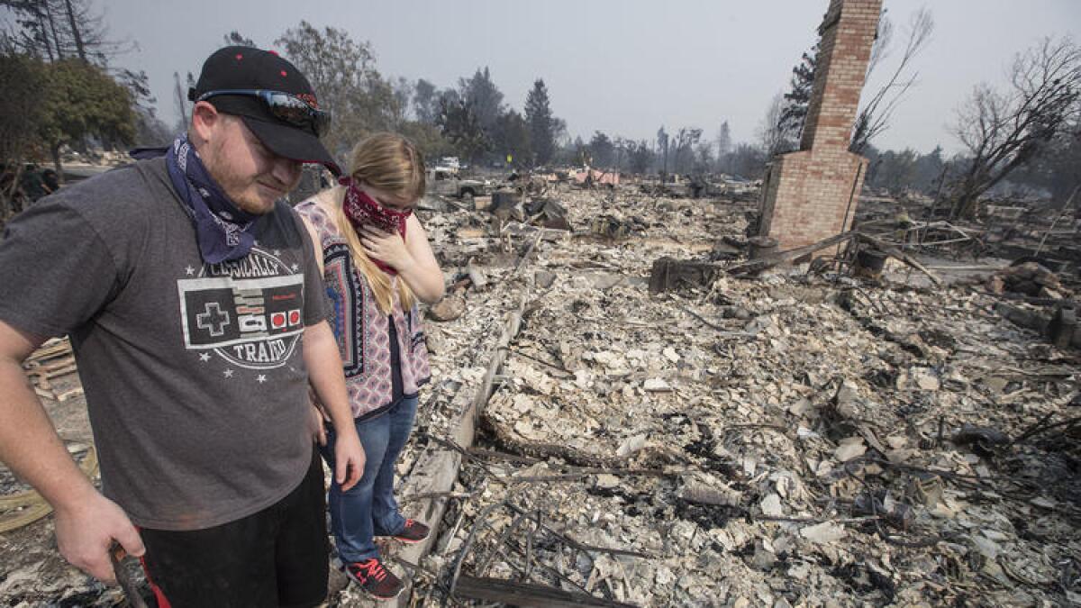 Spencer Blackwell, left, and Danielle Tate stand outside Tate's father's Santa Rosa home.