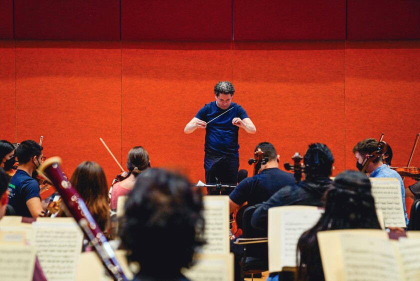 El director lidera un grupo de músicos.