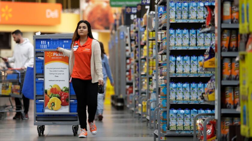 Laila Ummelaila, a personal grocery shopper at a Wal-Mart store in New Jersey, picks items off shelves for people who ordered online.